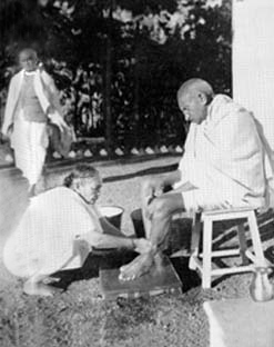 Kasturbai helping Gandhi to clean his feet after his evening walk, Bardoli, January 1939