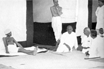 Gandhi discussing with his co-workers, Borsad Camp, May 1935